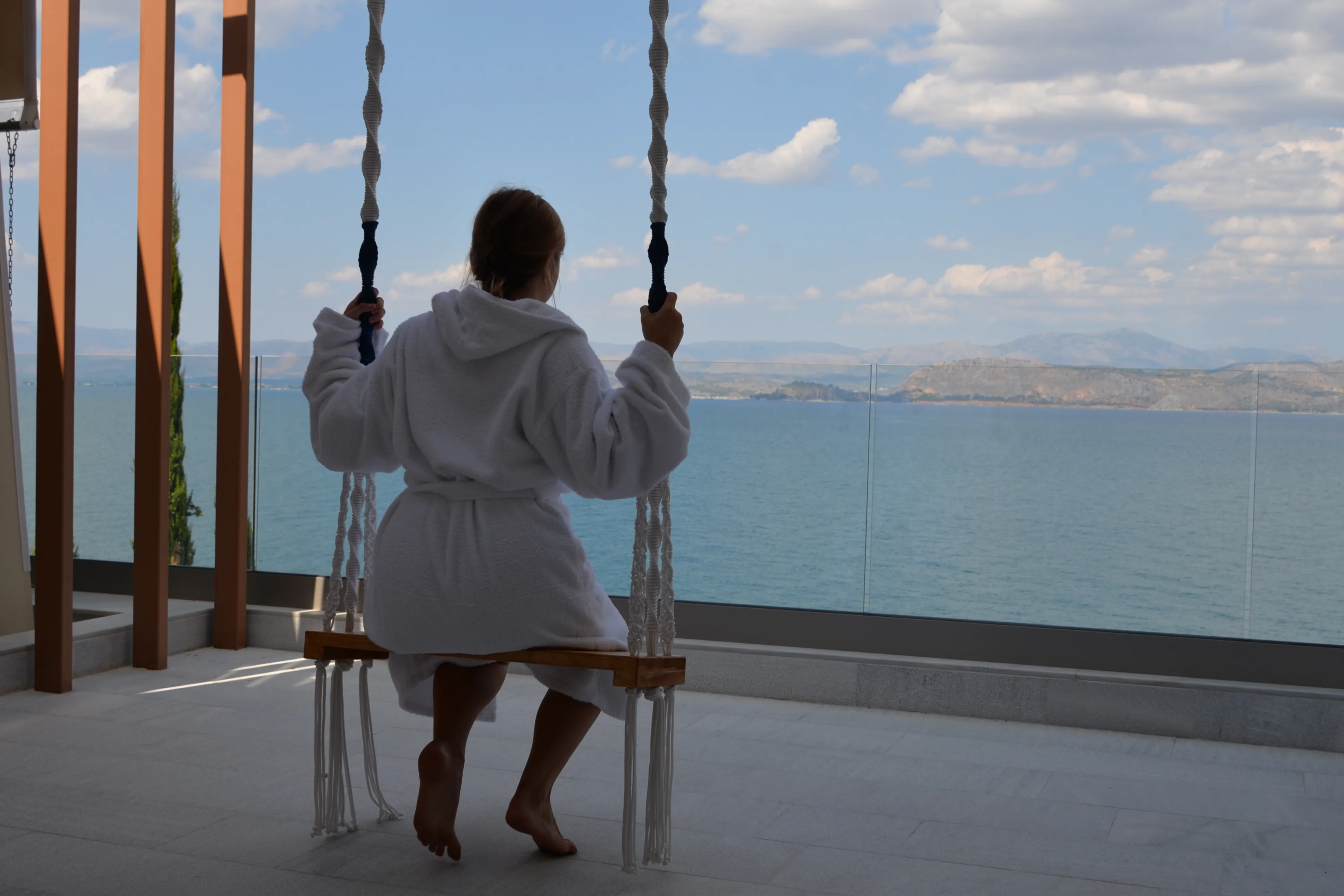 Guest on the Boreas terrace swing overlooking the Argolic Gulf